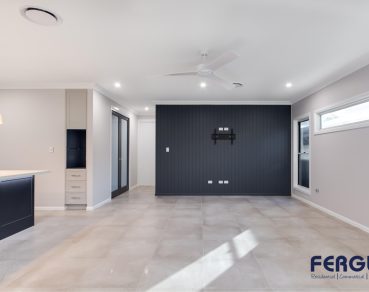 Modern Residential Indoor Living Room design featuring an elegant sliding door and a thoughtfully designed built-in TV rack partition by Fergus Builders Real Estate development Mackay